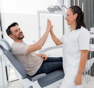 Patient high-fiving a dental team member
