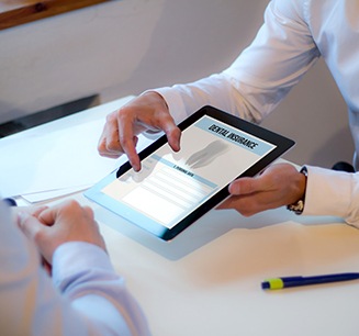 Showing patient a dental insurance form on a tablet